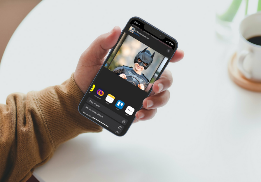 A hand holds an iPhone with the Save to Permanent feature on screen in front of a white table